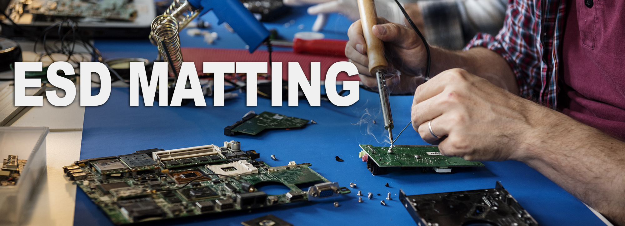 Closeup of ESD matting and soldering with electronics circuit board ESD MATTING